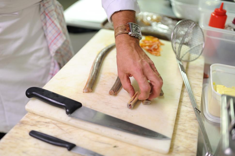 Personne qui découpe les anguilles en tronçons