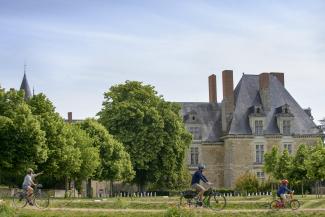 Famille à vélo devant le château de Durtal