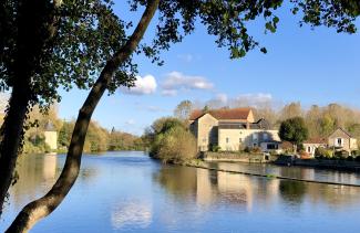Vue sur le Loir à Durtal en automne, avec le moulin et ses bâtiments anciens 