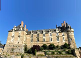 Vue en contre-plongée du château de Durtal, avec ses tours rondes et ses façades en tuffeau doré