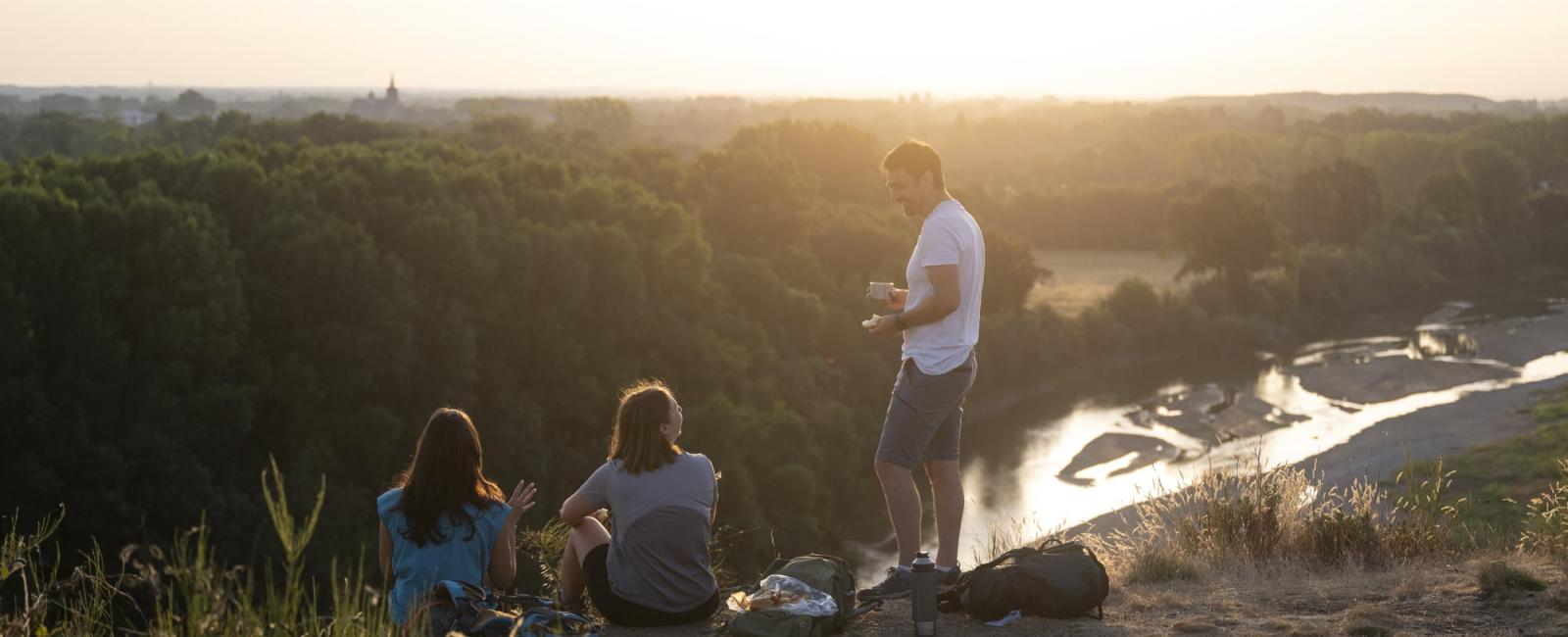 Randonneurs en haut d'un coteau avec vue sur la rivière Le Louet