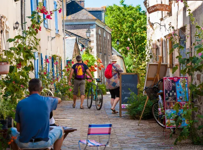 Promeneurs dans une ruelle pavée du village de Béhuard